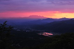 夕日に照らされた両神山と田