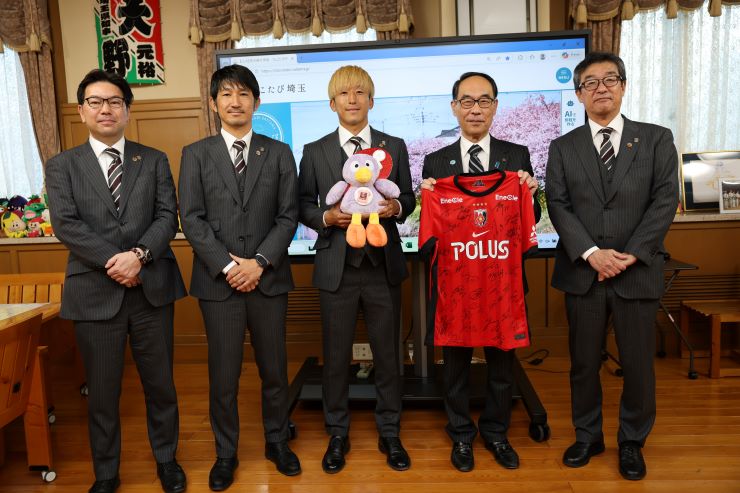 訪問者と記念写真を撮る知事の写真