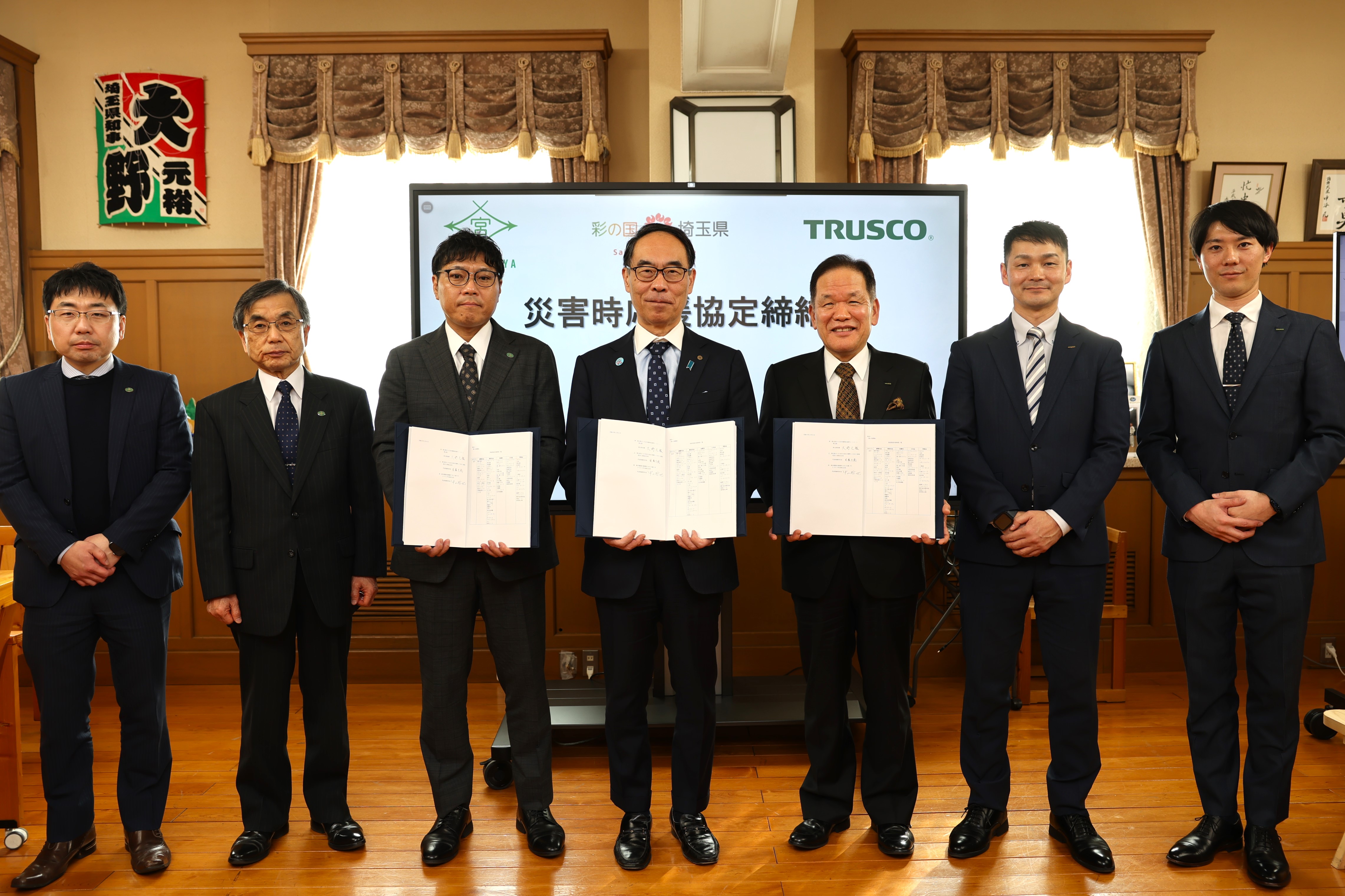 締結式で参加者と集合写真に写る知事の写真