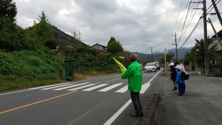 横断歩道で車に合図をするパトロール隊員