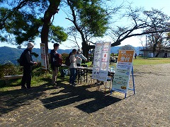 ハイキング参加者が受付している様子、横にイベント案内の看板