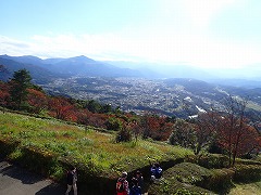 山頂展望台からの秩父盆地の眺め、写真下部でハイキング参加者が写真を撮っている