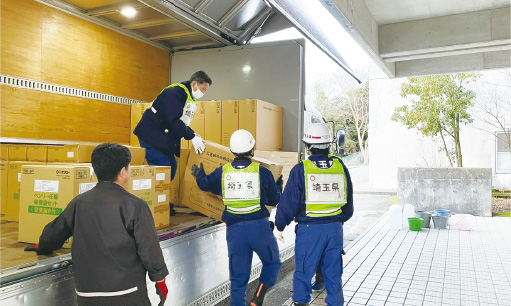 避難所に届いた物資を積み下ろす職員の写真