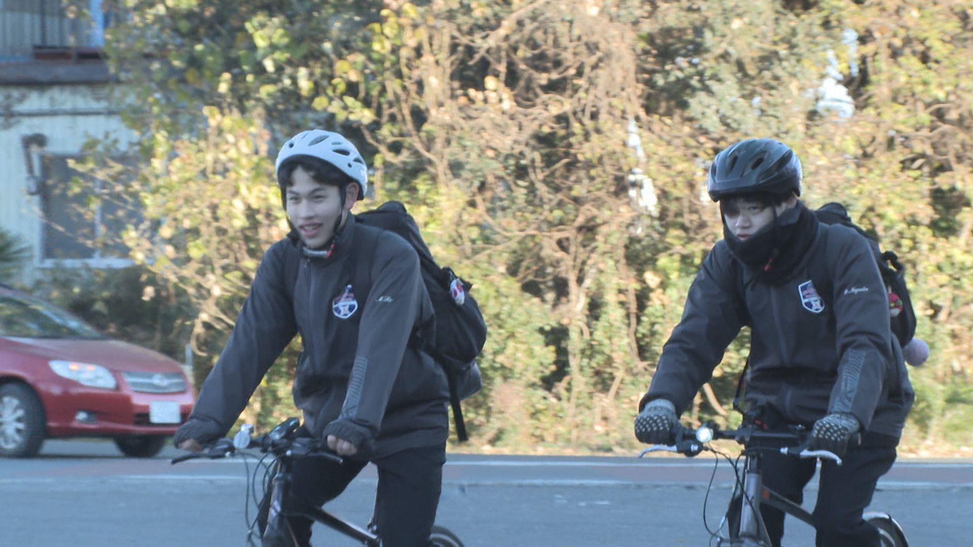 ヘルメットを着用して自転車に乗って登校する浦和東高校の生徒の様子の写真
