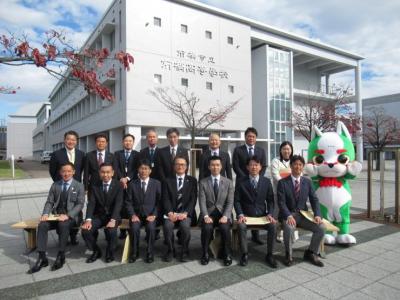 前橋市立前橋高等学校の校門前で委員とスタッフの集合写真