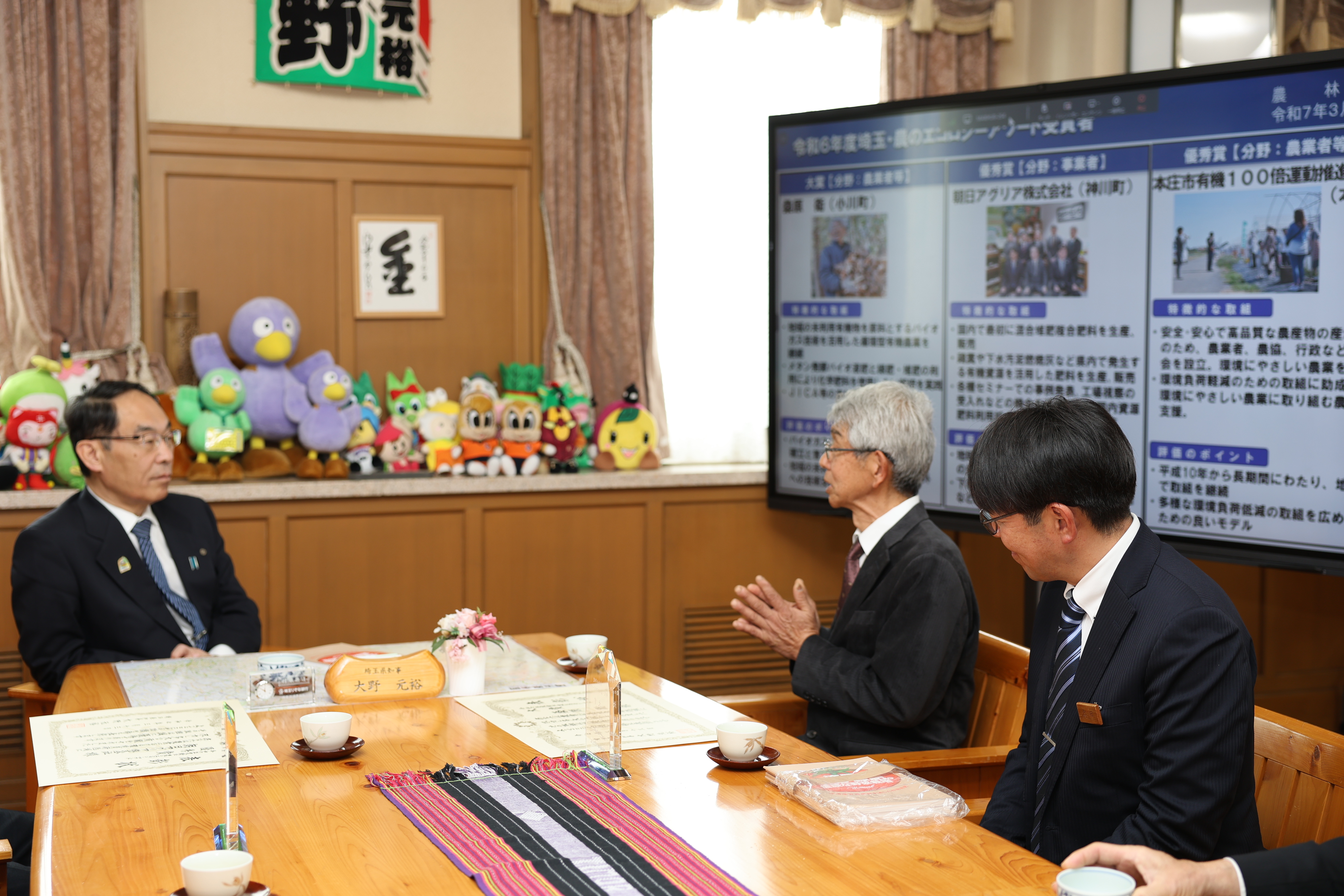 表敬訪問で訪問者と歓談する知事の写真