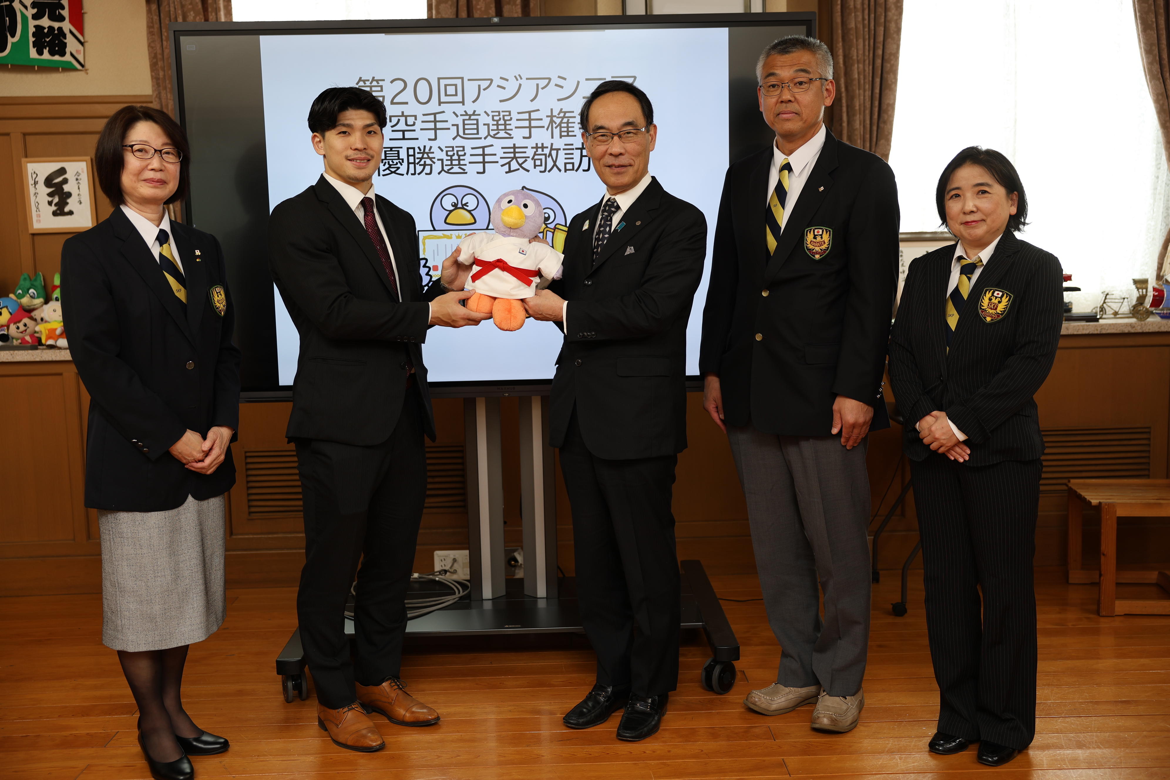 表敬訪問で訪問者と記念写真を撮る知事の写真