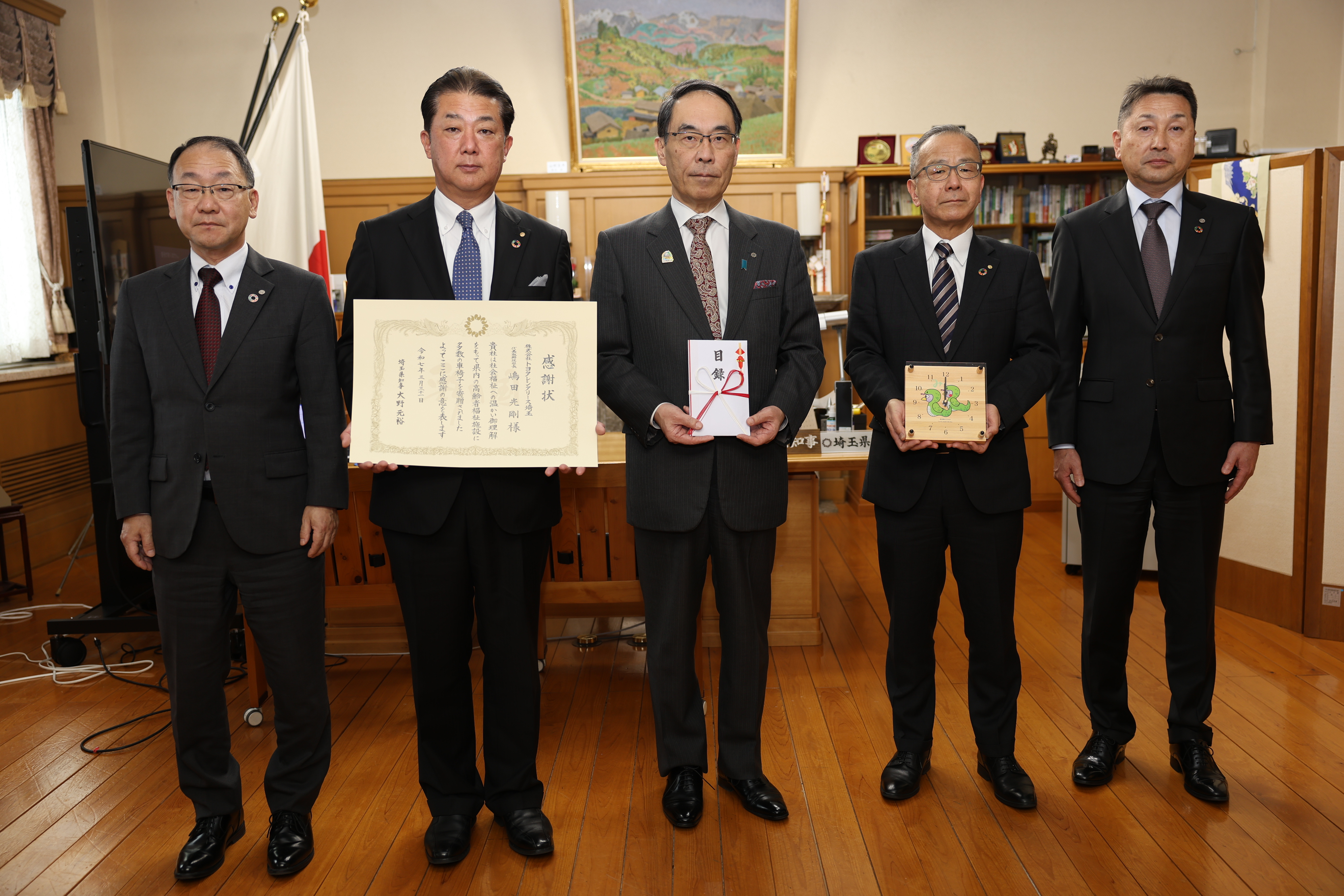 感謝状贈呈式で訪問者と記念写真を撮る知事の写真