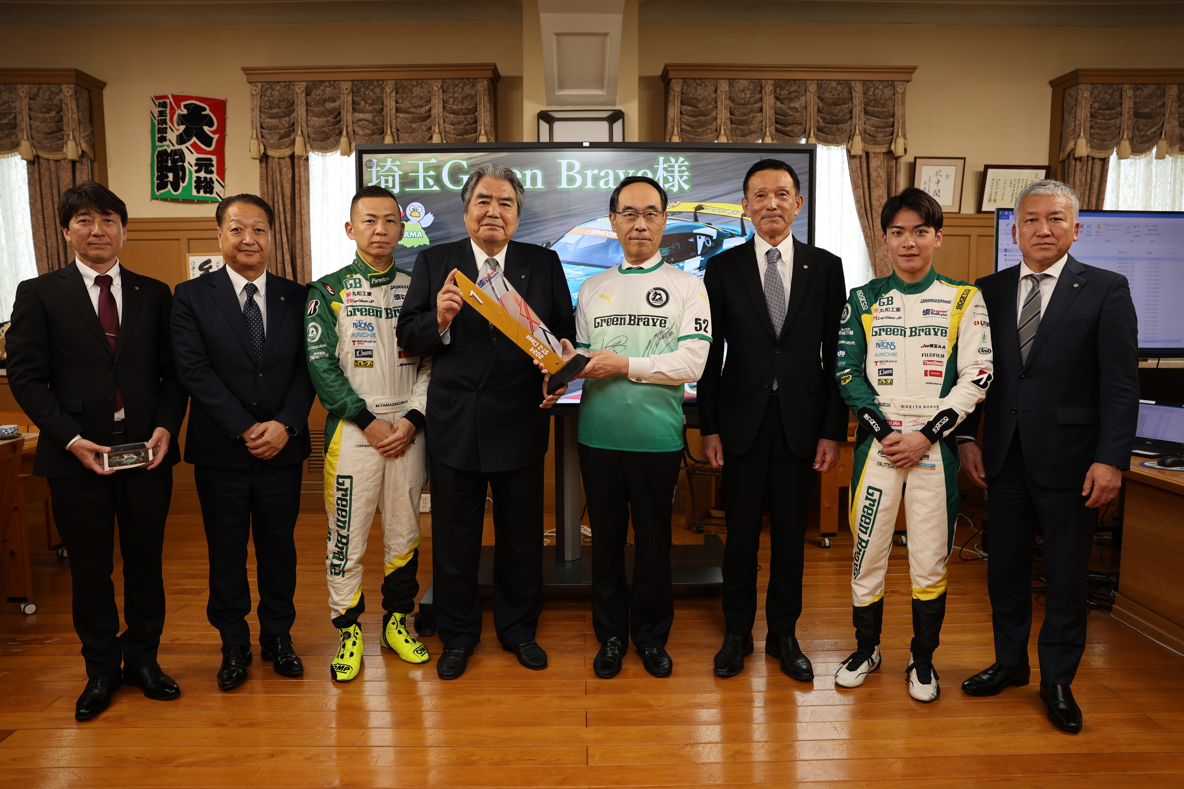 表敬訪問で訪問者と記念写真を撮る知事の写真