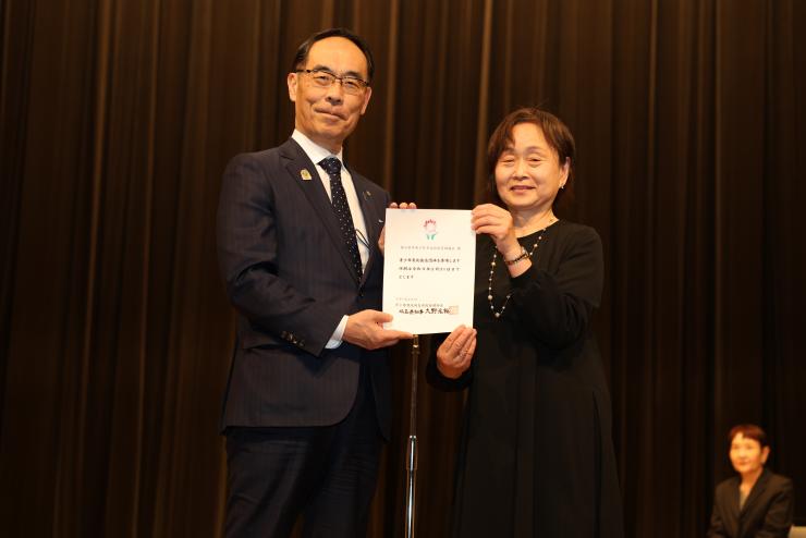 青少年育成推進団体委嘱式及び全体研修会で委嘱者と記念写真を撮る知事の写真