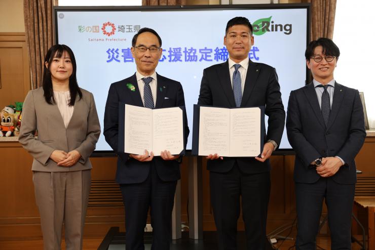 締結式で訪問者と記念写真を撮る知事の写真