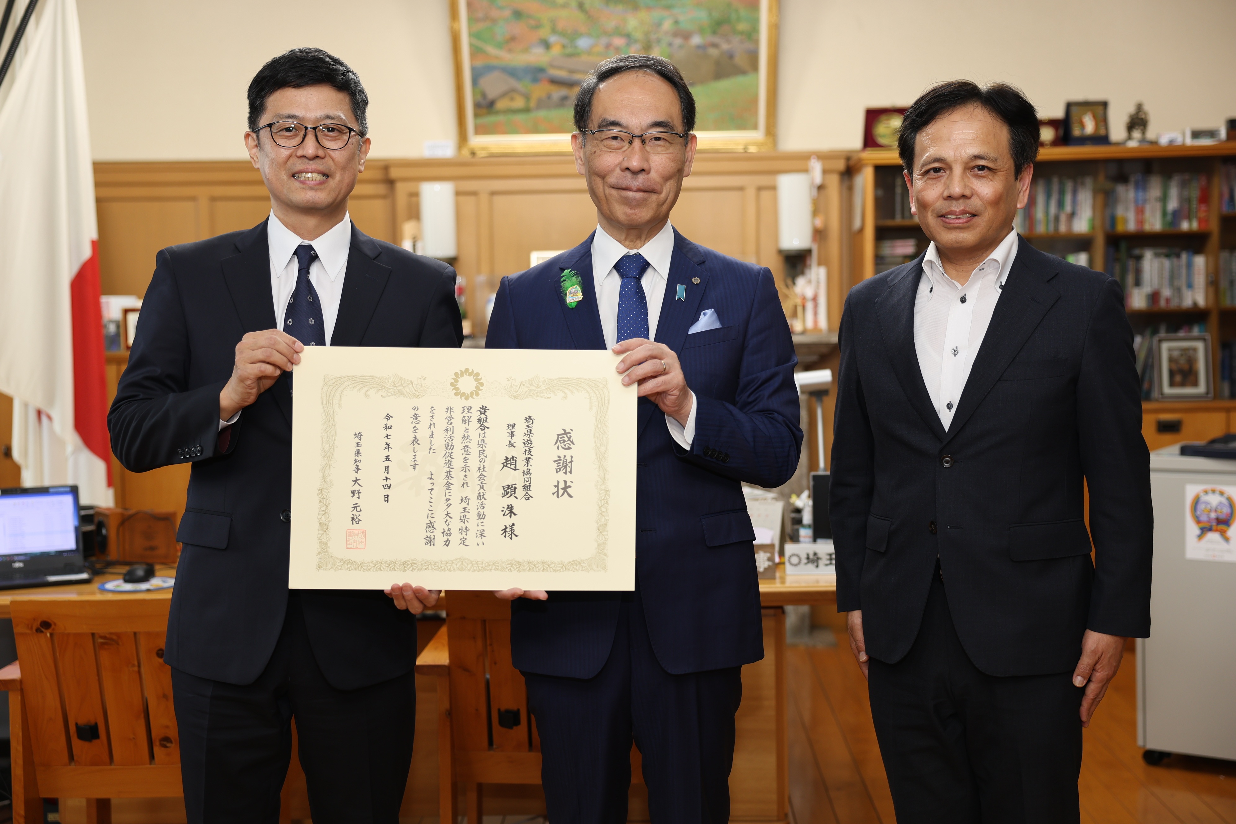 感謝状贈呈式で表彰者（埼玉県遊技業協同組合）と記念写真を撮る知事の写真