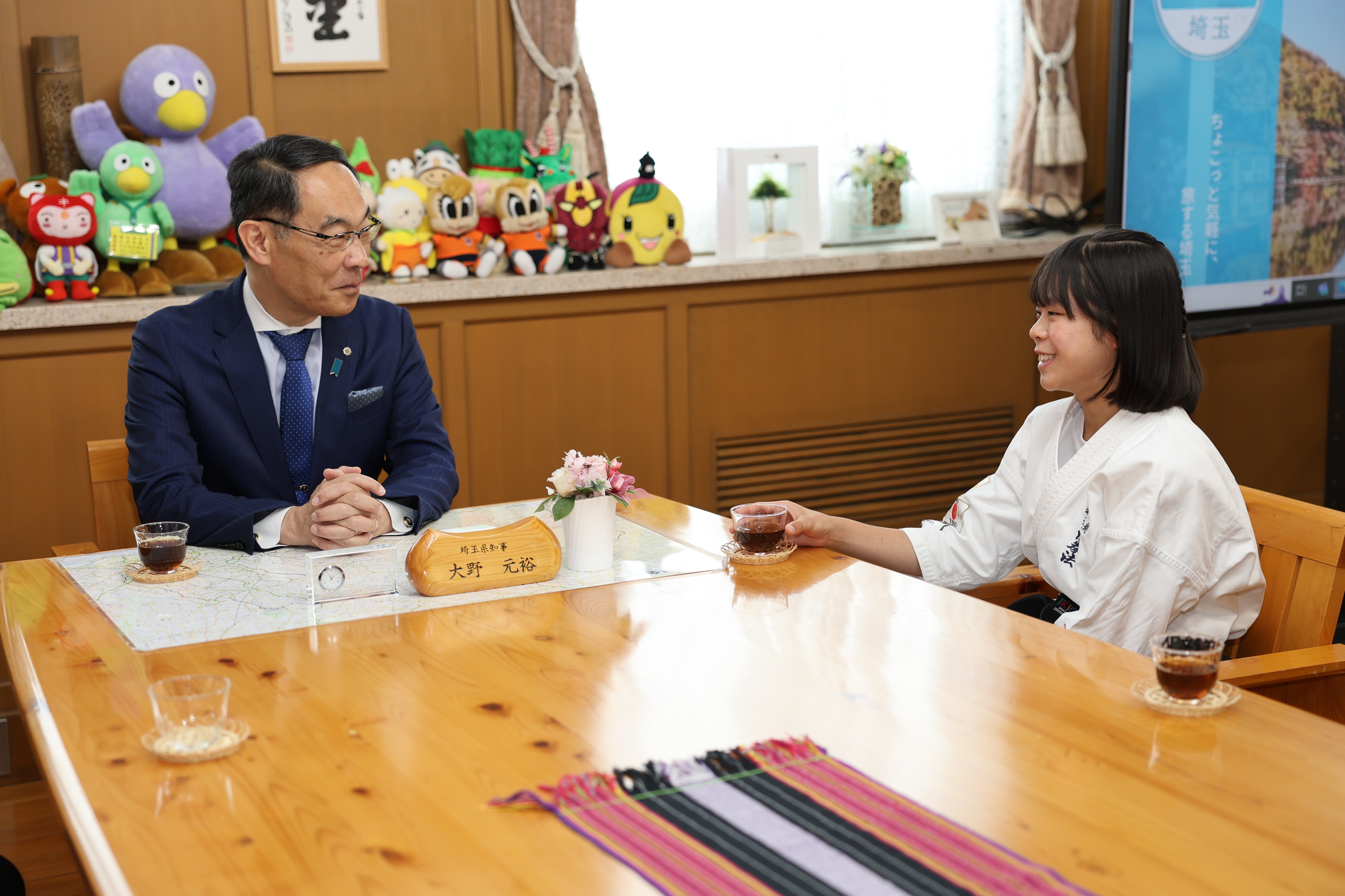 表敬訪問で訪問者と歓談する知事の写真