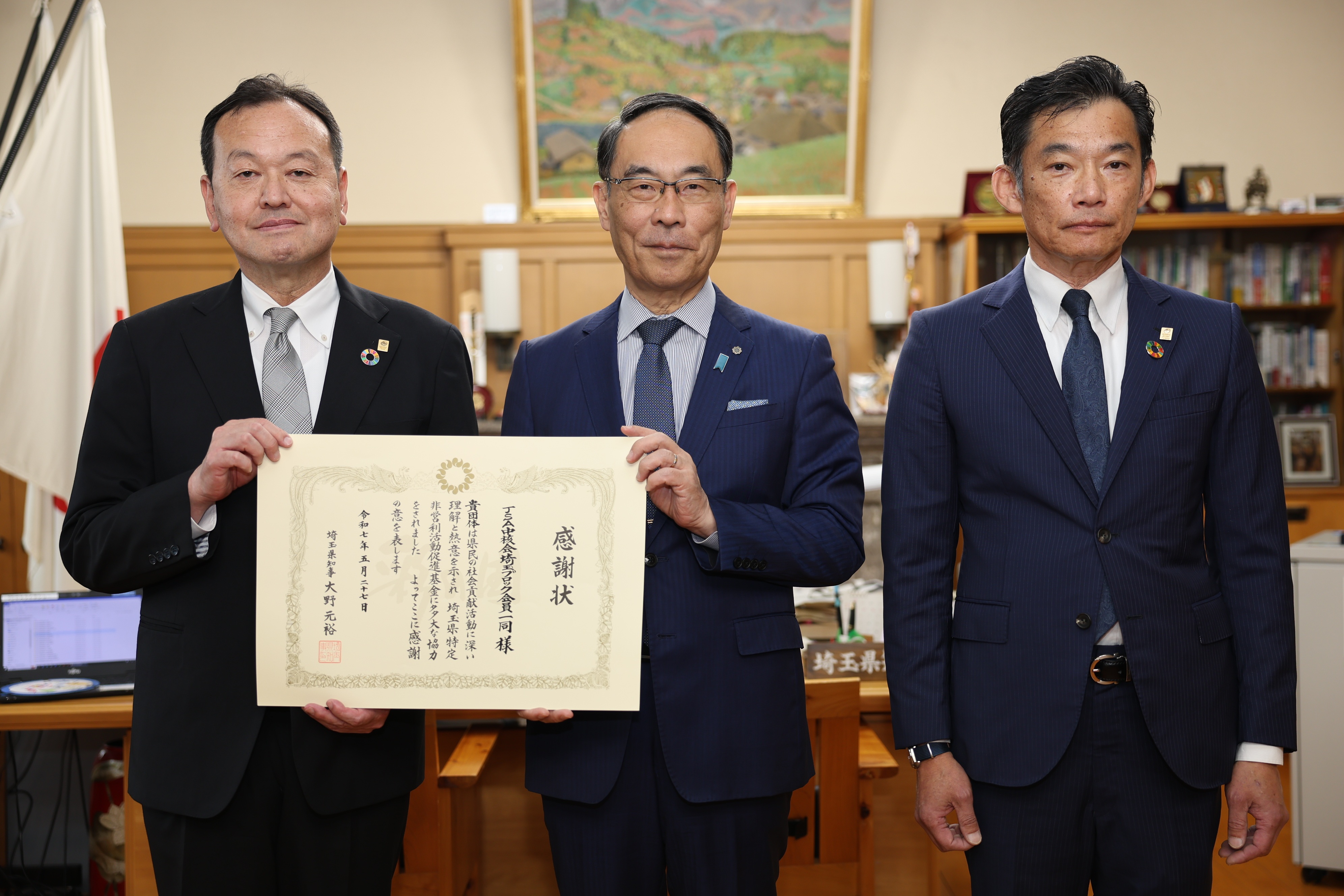 感謝状贈呈式で表彰者（JSA中核会埼玉ブロック）と記念写真を撮る知事の写真