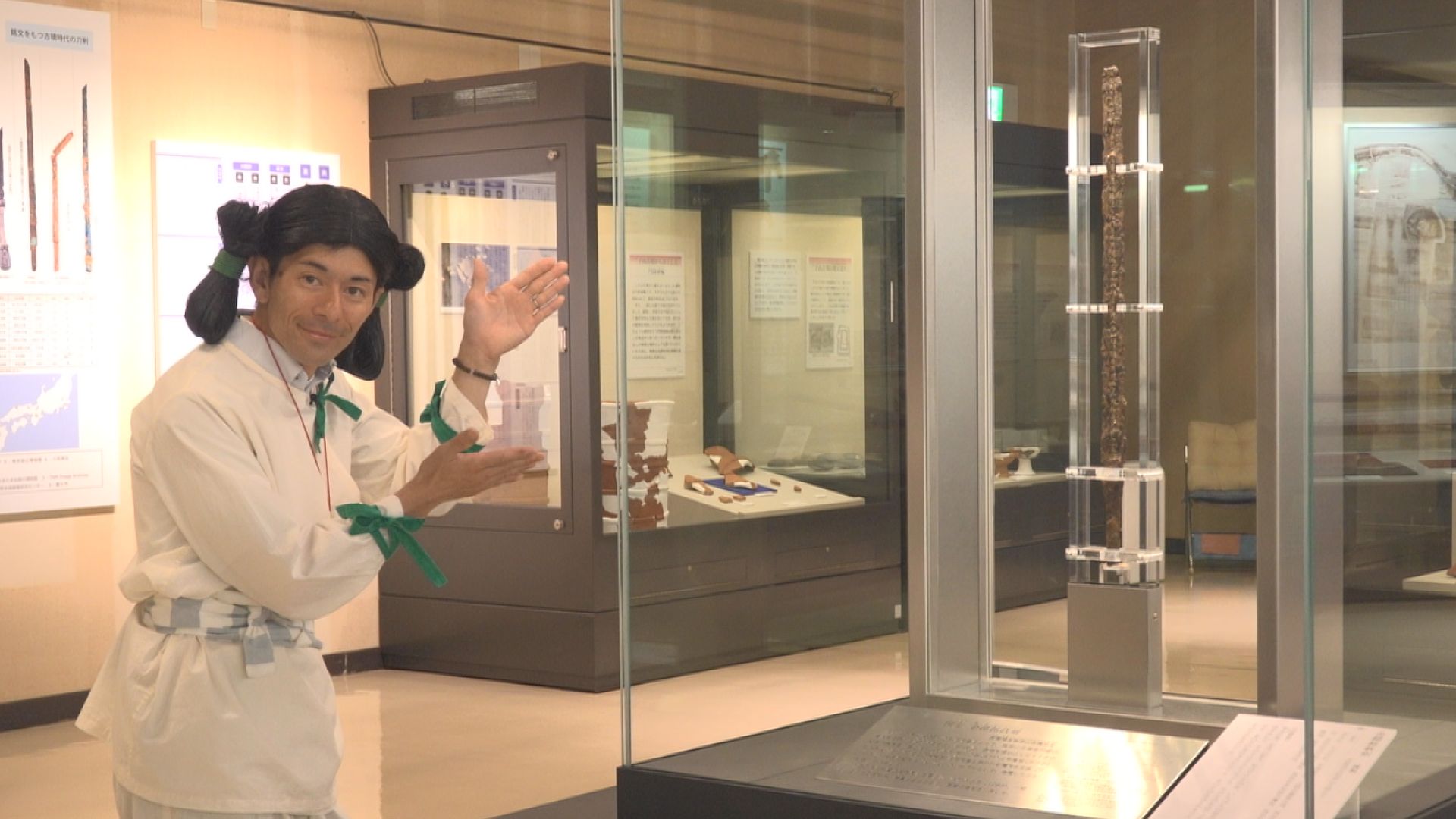 古代人が金錯銘鉄剣を案内している様子