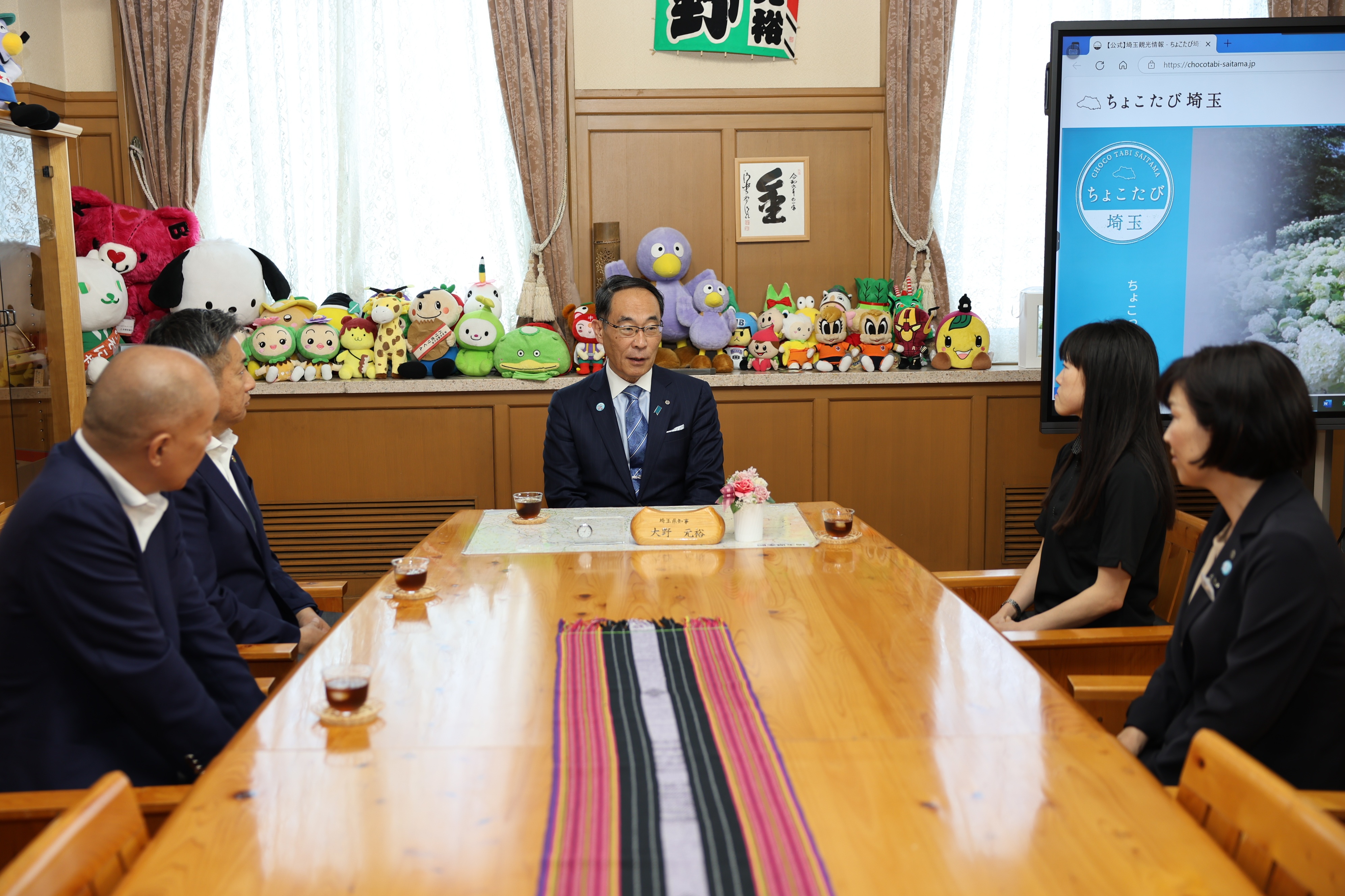 表敬訪問で訪問者と歓談する知事の写真