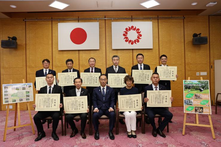 感謝状贈呈式で表彰者と記念写真を撮る知事の写真