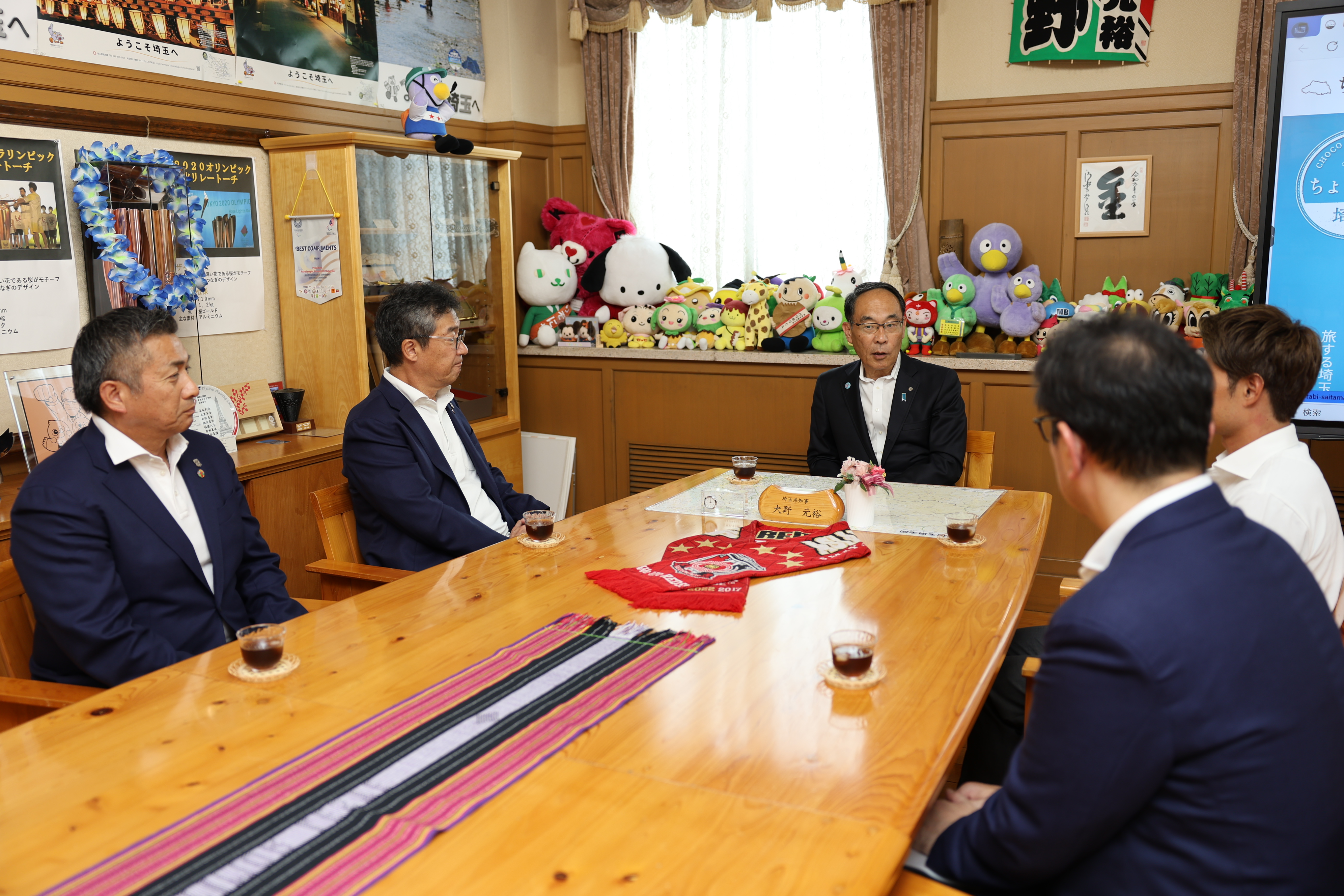 表敬訪問で訪問者と歓談する知事の写真