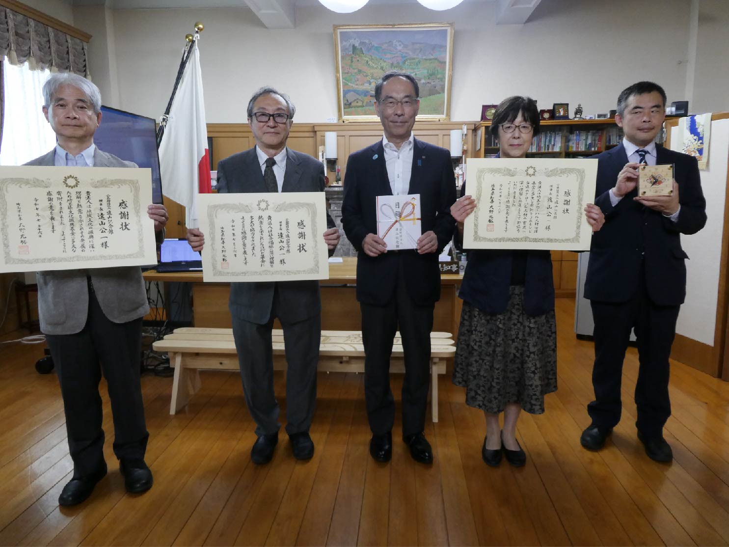 感謝状贈呈式で表彰者と記念写真を撮る知事の写真