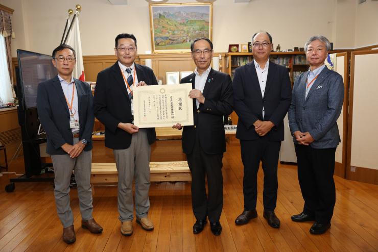 感謝状贈呈式で表彰者と記念写真を撮る知事の写真