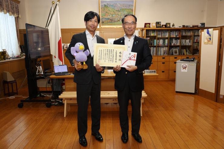 感謝状贈呈式で表彰者と記念写真を撮る知事の写真