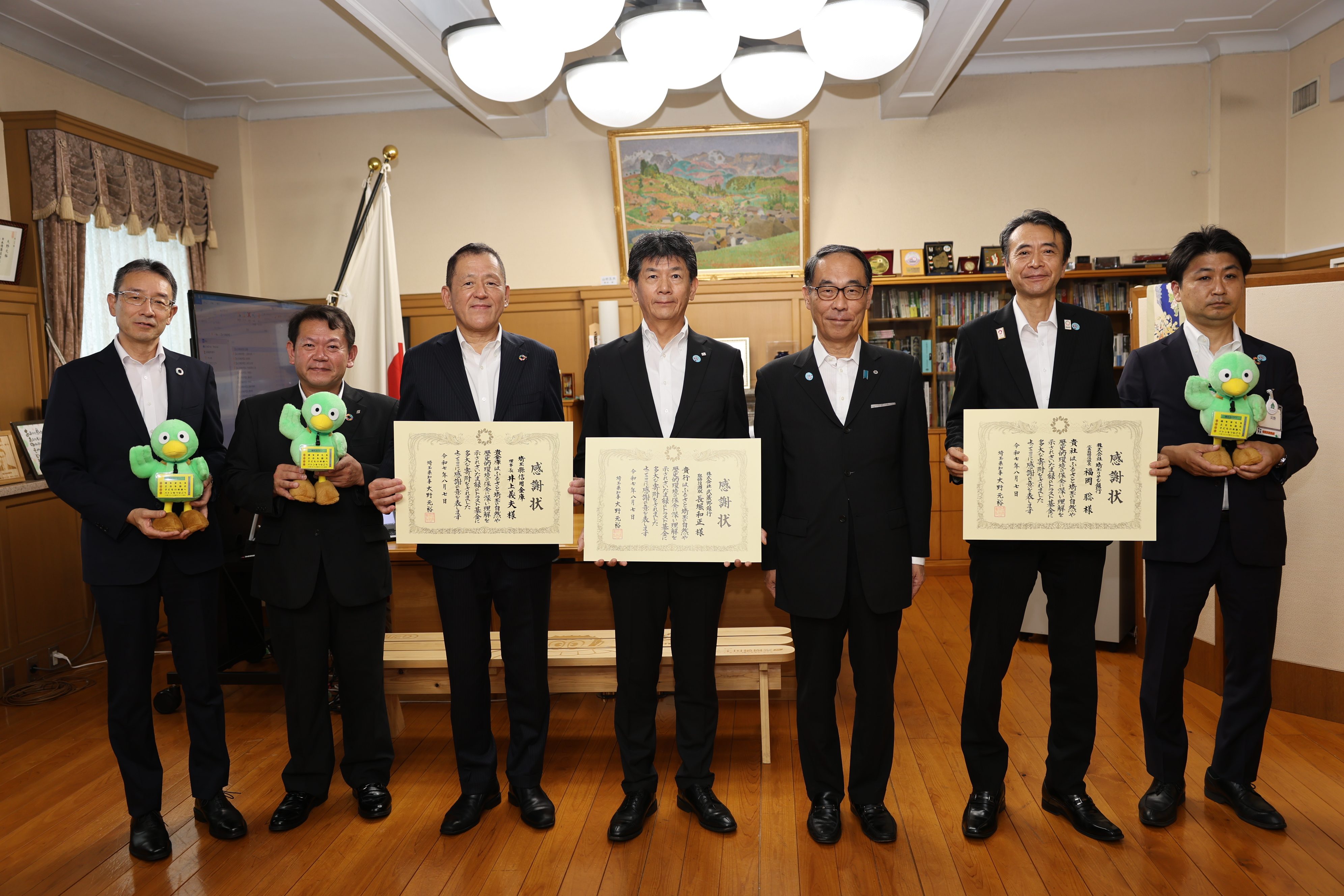 感謝状贈呈式で表彰者と記念写真を撮る知事の写真