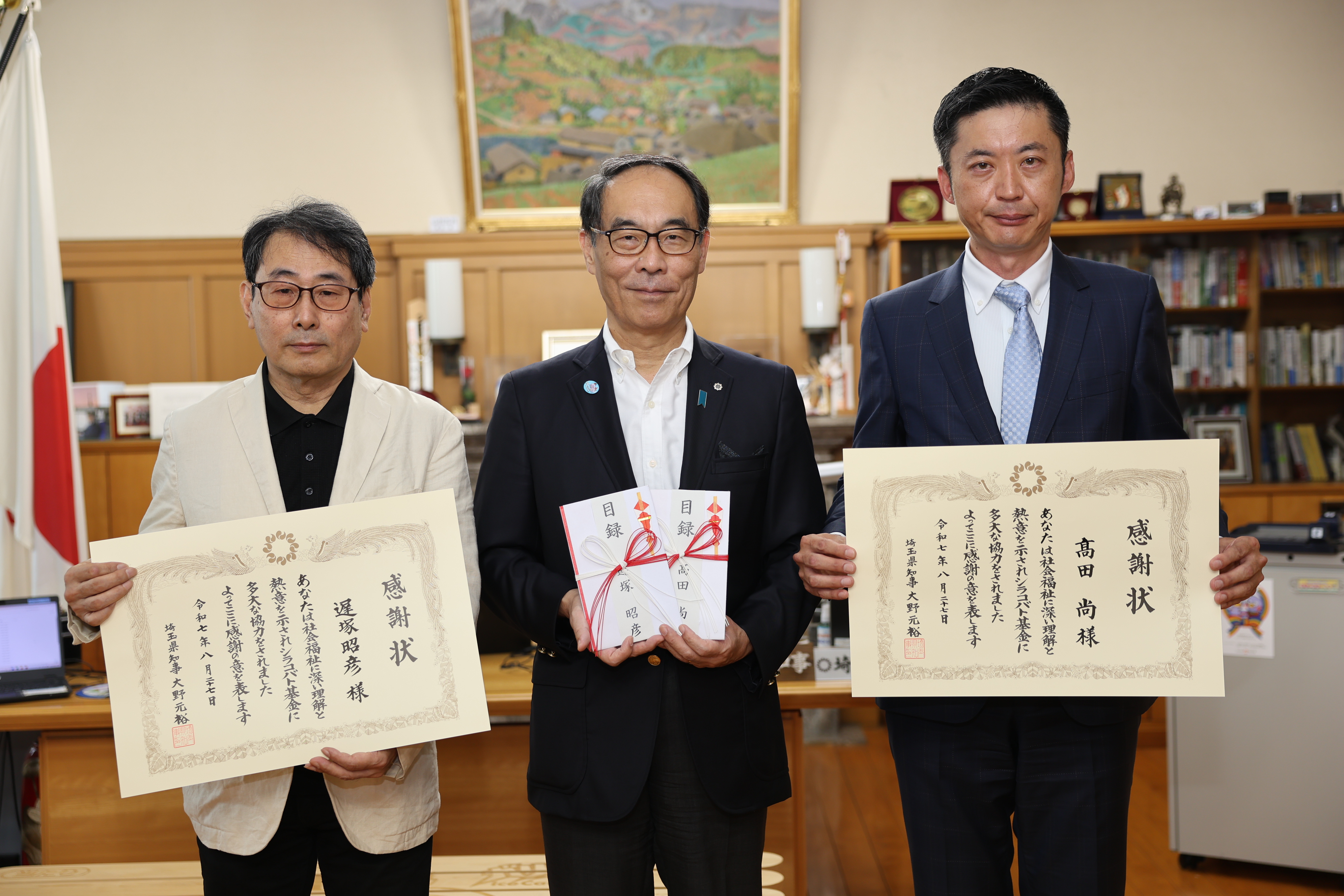 感謝状贈呈式で表彰者と記念写真を撮る知事の写真