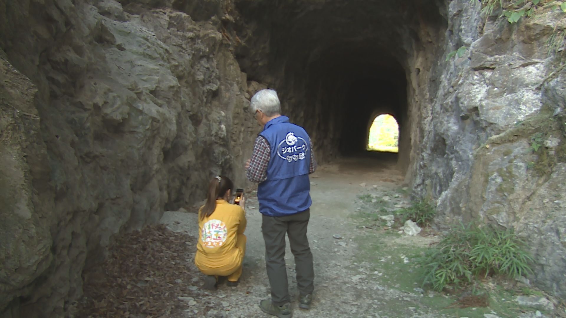 大達原の手掘りトンネルで写真を撮る才木玲佳と職員