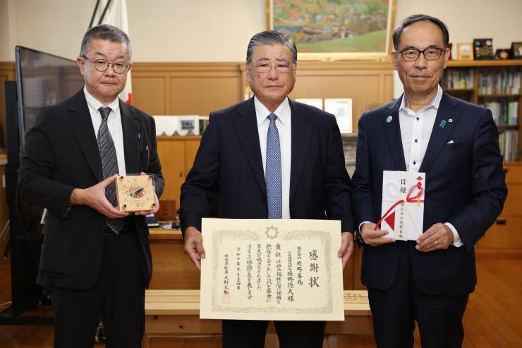 表敬訪問で訪問者と記念写真を撮る知事の写真