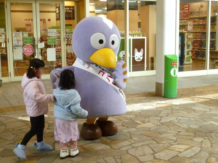 コバトンと触れ合うこどもの写真