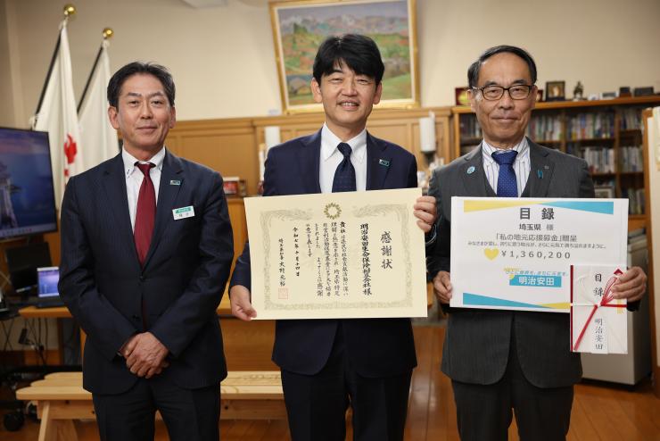 感謝状贈呈式で表彰者と記念写真を撮る知事の写真