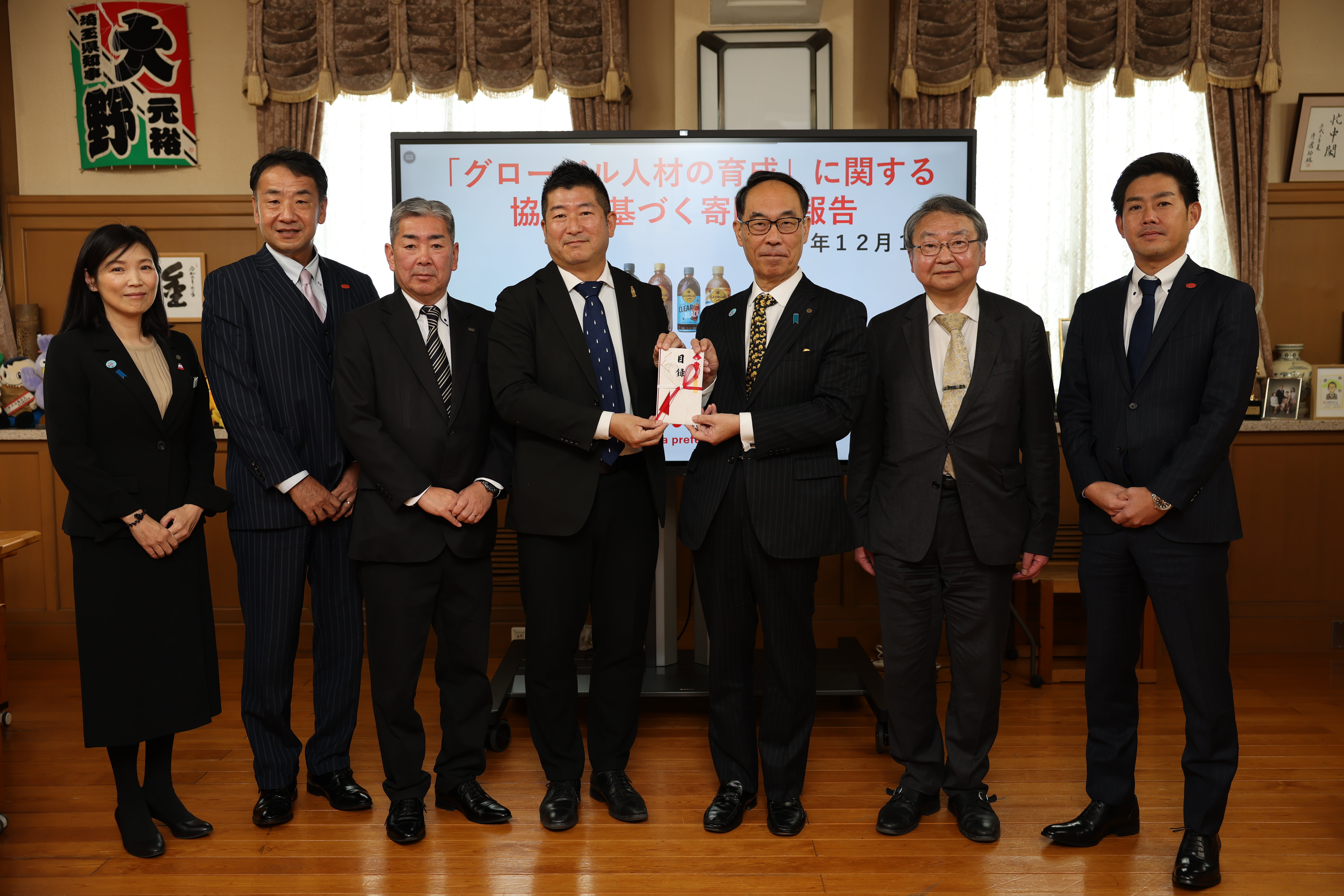 贈呈式に寄附者とともに記念写真を撮る知事の写真