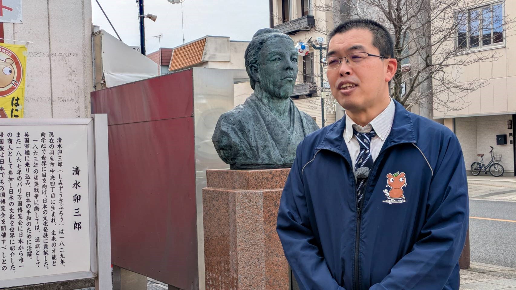清水卯三郎の胸像について説明する羽生市の学芸員