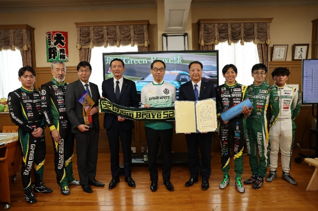 訪問者と記念写真を撮る知事の写真