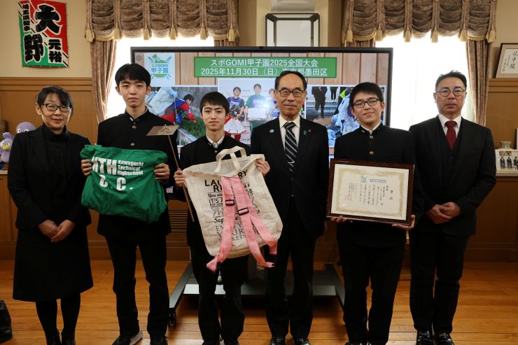 訪問者と記念写真を撮る知事の写真