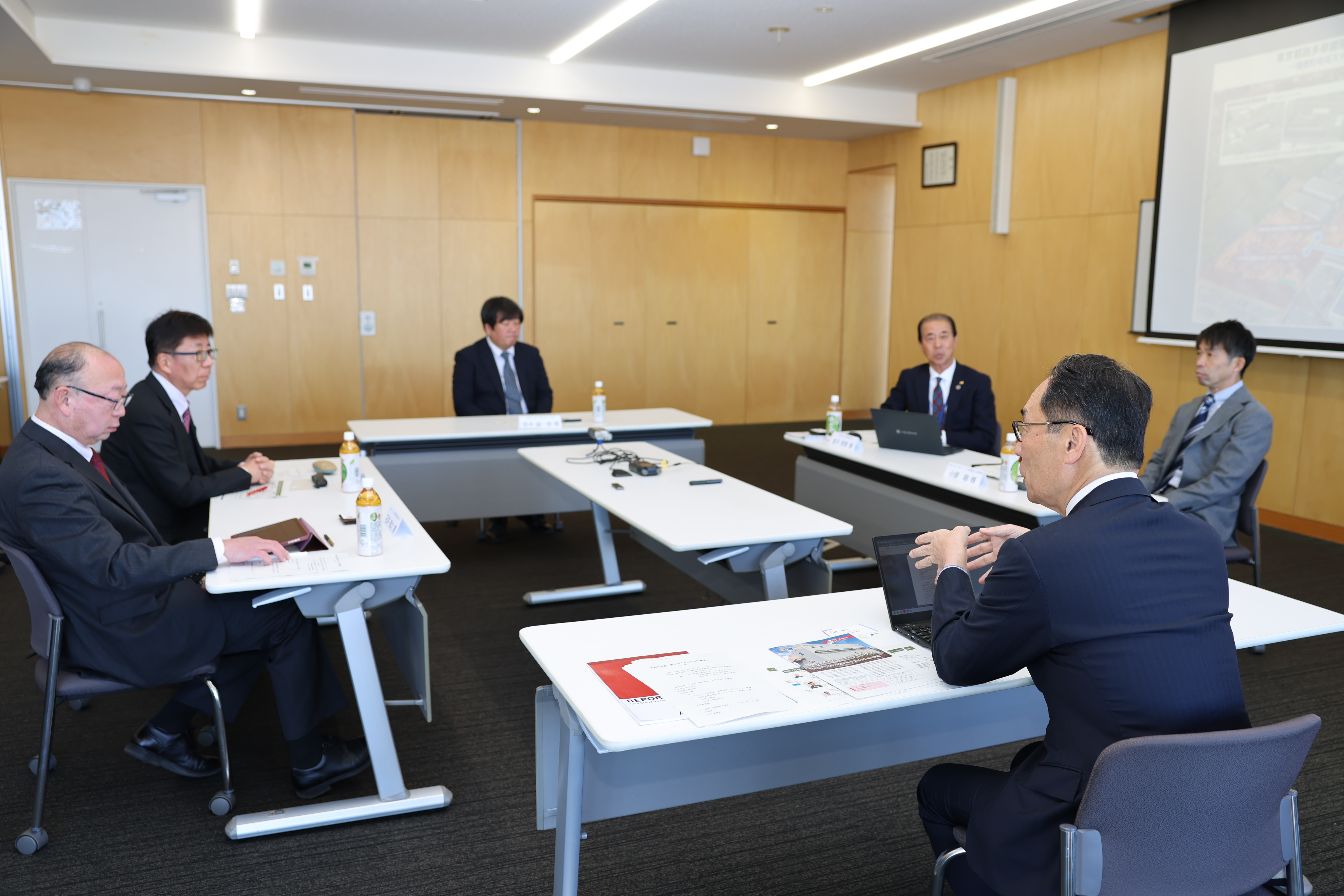 訪問先の担当者と歓談する知事の写真