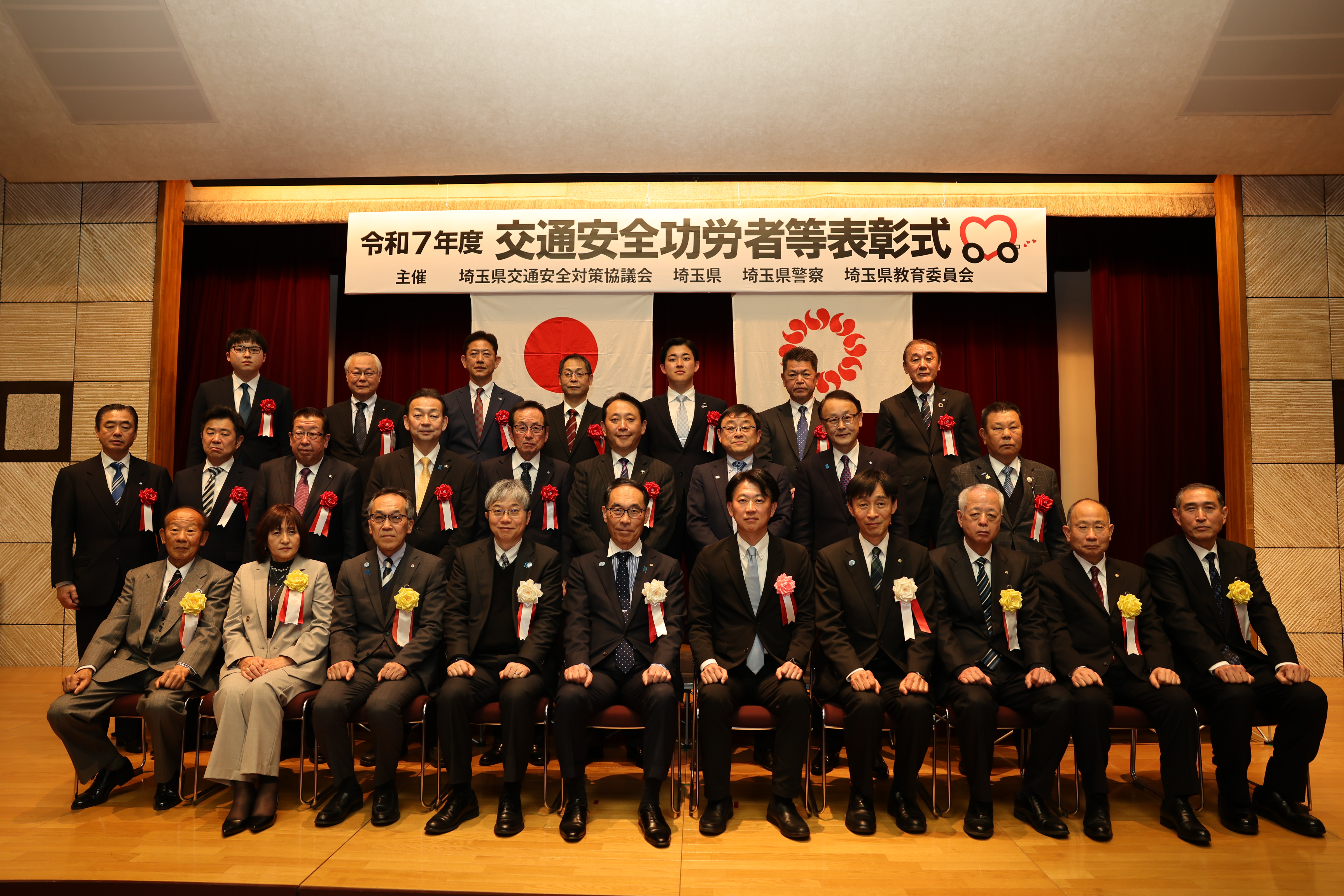 表彰者と集合写真に写る知事の写真