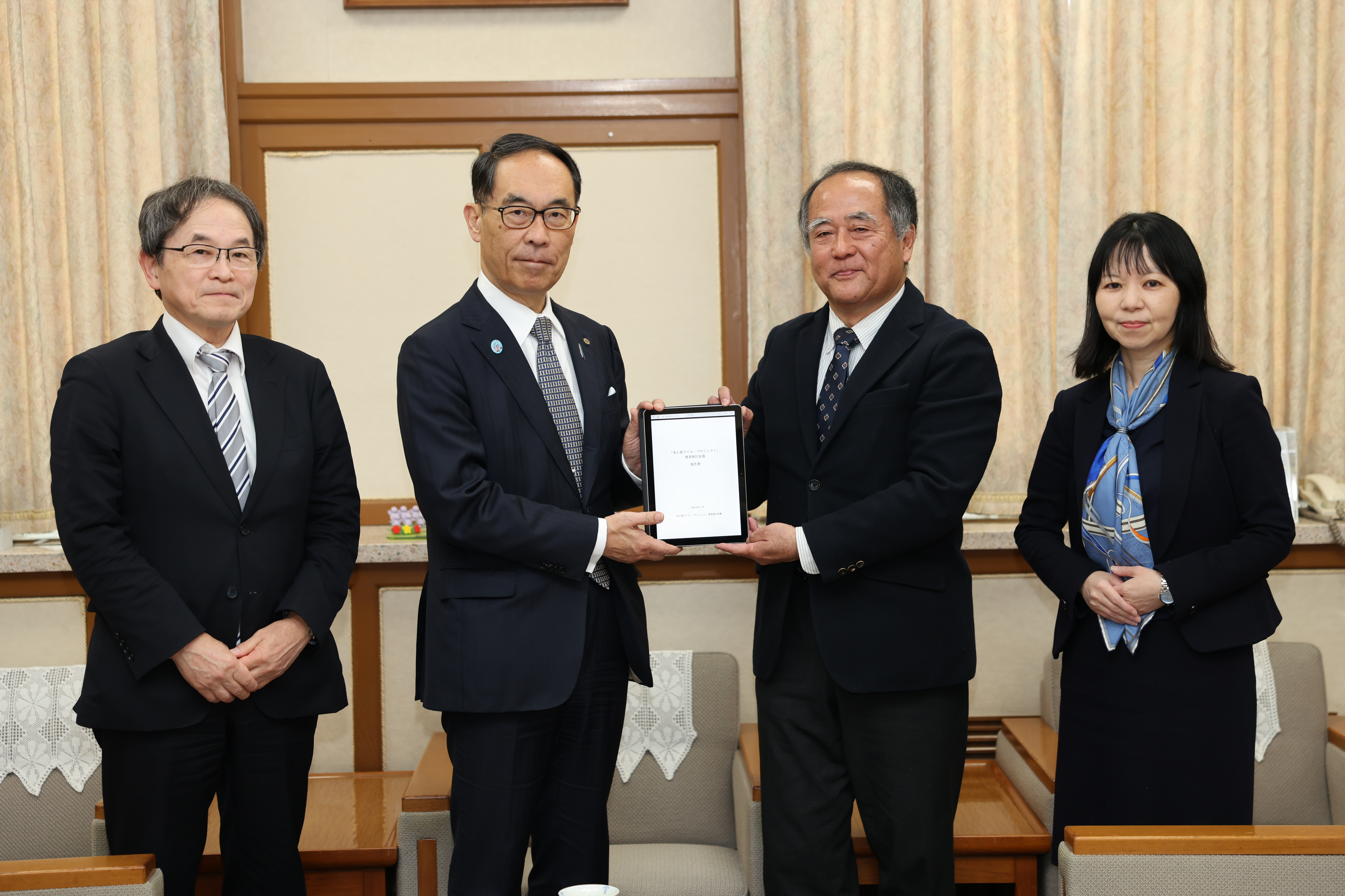 知事報告の出席者と記念写真を撮る知事の写真