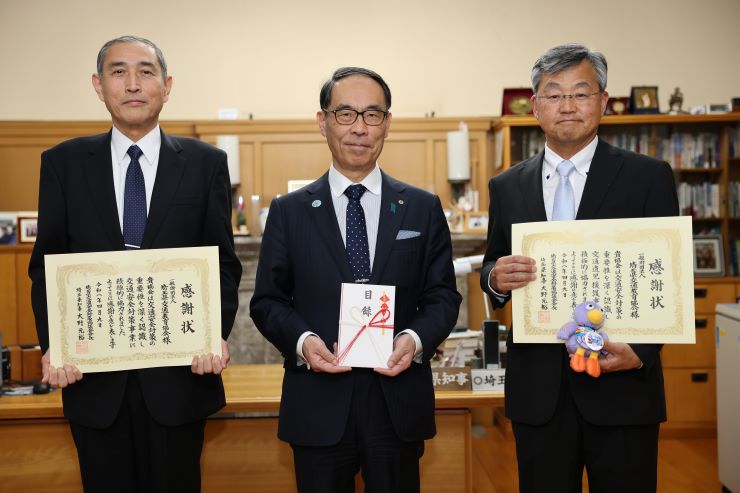 寄附いただいた方々と記念撮影を取る知事の写真
