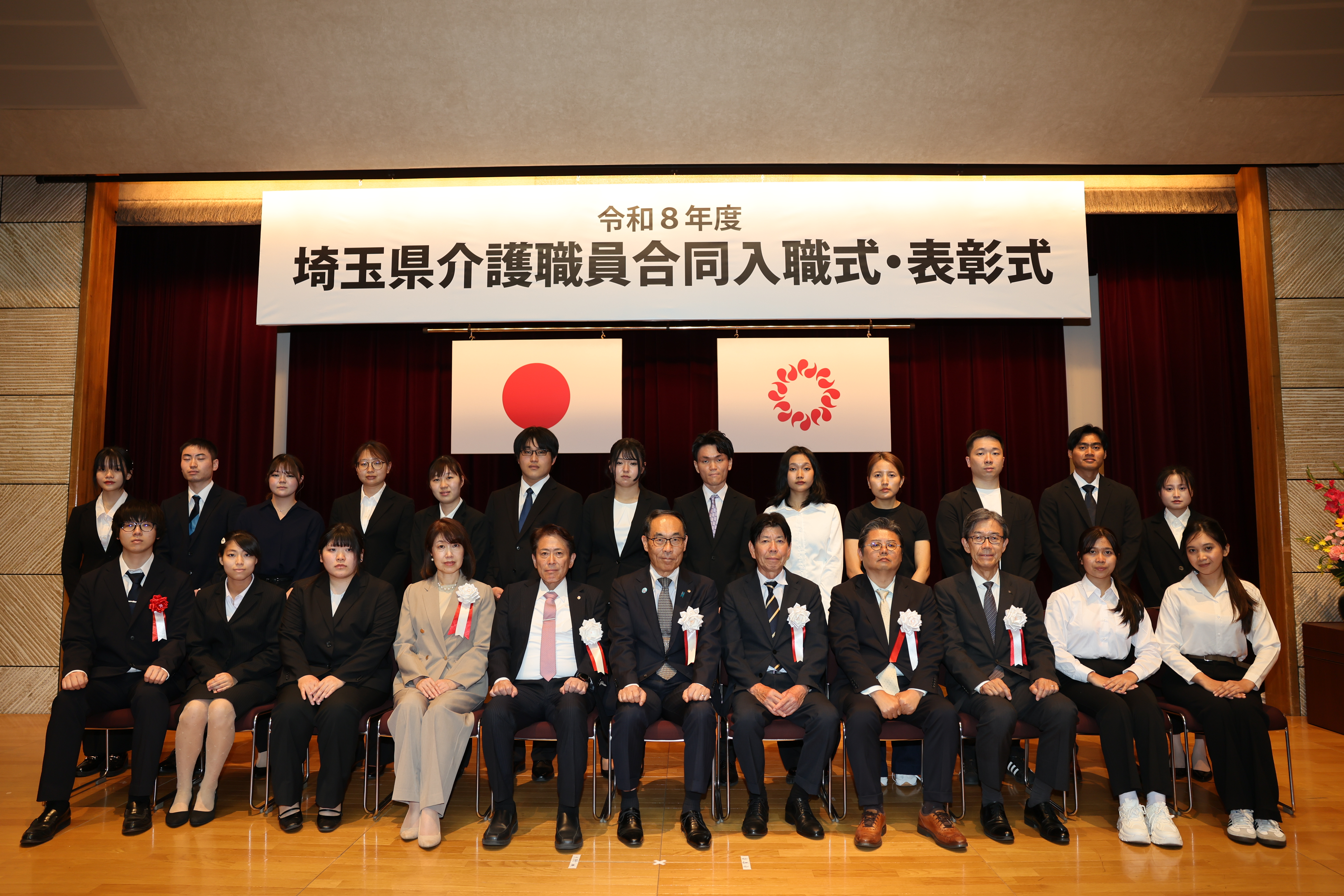 入職式・表彰式で記念写真を撮る知事の写真