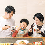 家族でご飯を食べる写真