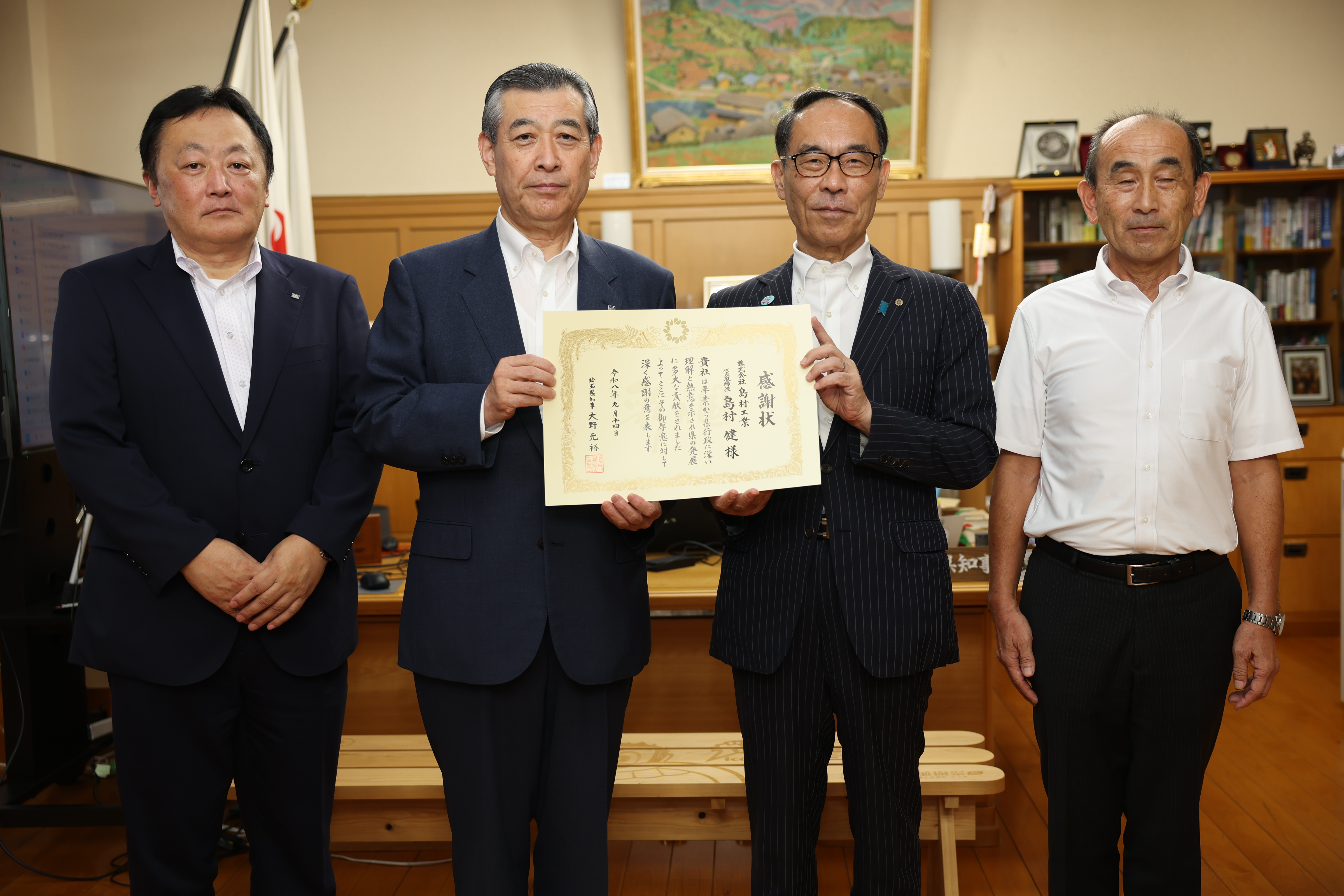 感謝状贈呈者と記念写真を撮る知事の写真