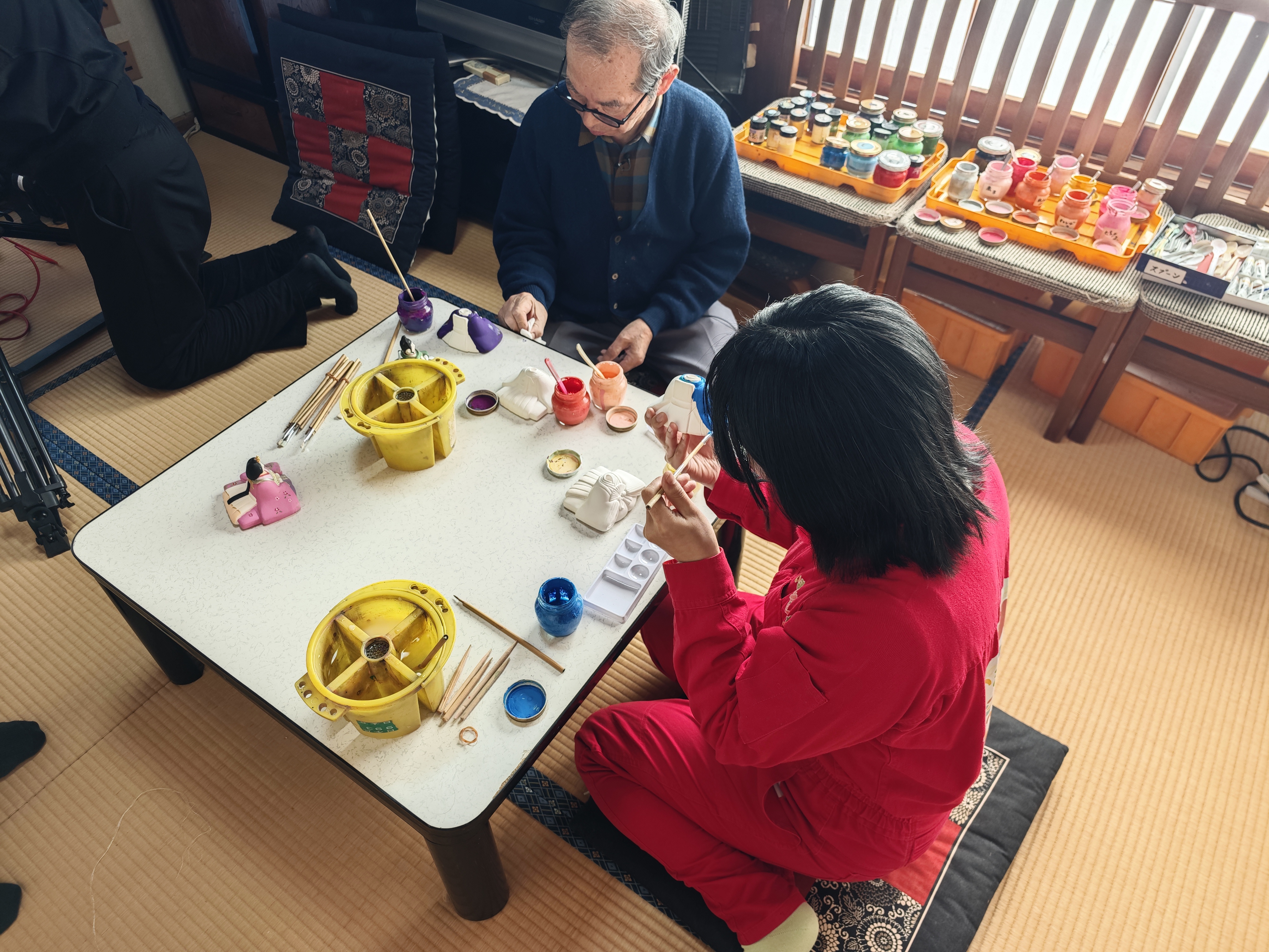 アンゴラ村長と人形職人が絵付けをする